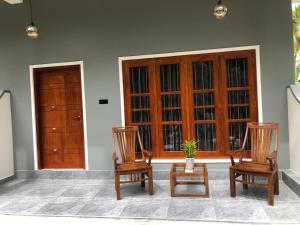 two wooden chairs sitting in front of a door at The BLISS Mihiripenna in Talpe