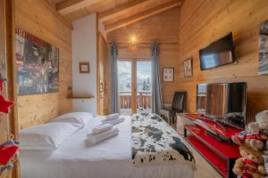 a bedroom with a bed and a television in a cabin at Alpine Luxury Chalet Pool & Jacuzzi in Cordon