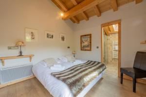 a bedroom with a large bed and a chair at Alpine Luxury Chalet Pool & Jacuzzi in Cordon +28 photos