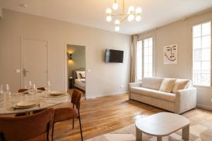 a living room with a table and a couch at Charming and spacious air-conditioned apartment in Le Pré-Saint-Gervais +12 photos