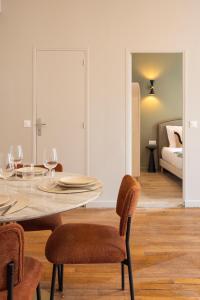 a dining room with a table and chairs and a bedroom at Charming and spacious air-conditioned apartment in Le Pré-Saint-Gervais