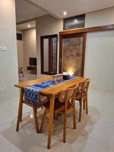 a dining room table with chairs and a table cloth on it at Omi Homestay in Praya