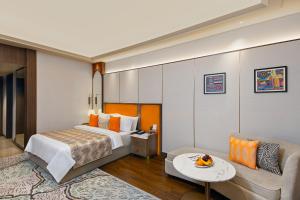 una camera d'albergo con un letto e un divano di Fortune Select Siliguri a Binnāguri