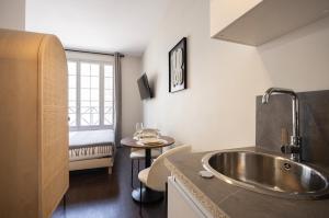 a bathroom with a sink and a bed in a room at Air-conditioned and cozy haven in Le Pré-Saint-Gervais
