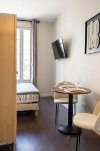 a room with a bed and a table and a chair at Air-conditioned and cozy haven in Le Pré-Saint-Gervais