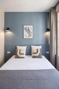 a bedroom with a large white bed with two pillows at Air-conditioned and cozy haven in Le Pré-Saint-Gervais
