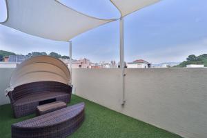 een patio met 2 stoelen en een parasol op een dak bij Rubato Hotel Ulsan Junggu in Ulsan