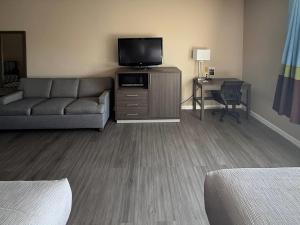 een woonkamer met een bank en een televisie bij Quality Inn Ormond Beach - Daytona in Ormond Beach