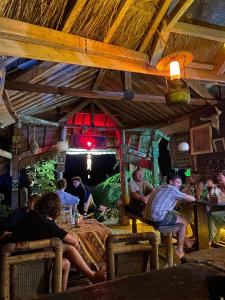 un gruppo di persone sedute a un tavolo in un pub di Satu Lingkung a Tetebatu