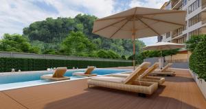 a group of chairs and umbrellas next to a pool at Zen Essence Khao Yai in Ban Tha Maprang