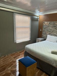 a bedroom with two beds and a blue stool at Lake boutique hotel empire in Thohoyandou