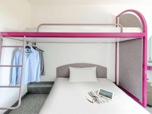 um beliche com um beliche cor-de-rosa em ibis budget Berlin Airport Schönefeld em Schönefeld