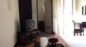 een woonkamer met een tv en een bank bij Baan Pim in Chiang Mai