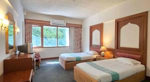 una camera d'albergo con due letti e una scrivania di Pailyn Hotel a Sukhothai Altre 158 foto