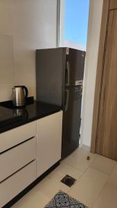 a kitchen with a stainless steel refrigerator in a room at sun in Būbādī