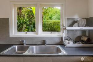 a kitchen sink with two windows above it at Taman Indrakila in Ubud +35 photos