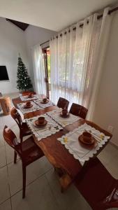 een eettafel met stoelen en een kerstboom bij Chalé no Privê Monte Serrat com 3 quartos em Gravatá in Gravatá +44 foto's