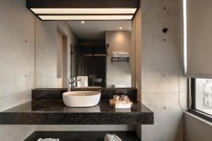a bathroom with a sink and a large mirror at HOYU INN's in T'ien-liao