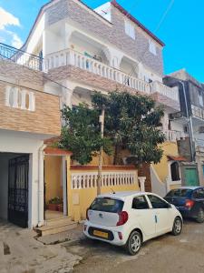 een witte auto geparkeerd voor een huis bij Résidence Choco in Tabarka