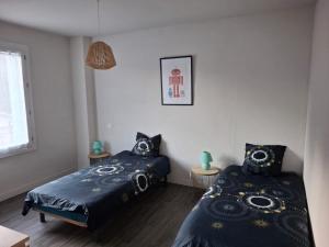 a bedroom with two beds and a window at Gîte l'Ermitage in Cahors