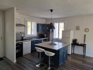 a kitchen with blue cabinets and a island in it at Gîte l'Ermitage in Cahors