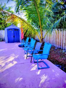 een rij blauwe stoelen naast een hek bij Perfect Beach Gateway in West Palm Beach