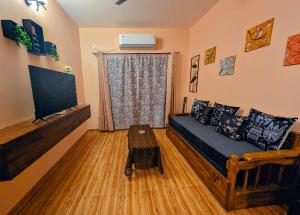 a living room with a couch and a flat screen tv at Ketaki Homestay in Shānti Niketan