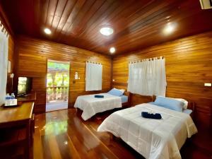 - une chambre avec 2 lits dans une pièce en bois dans l'établissement Phuphan Park Hotel, à Ban Si Wicha