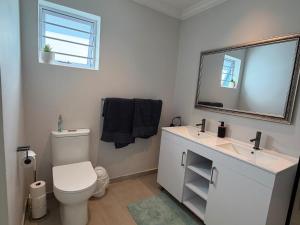 a bathroom with a white toilet and a mirror at Ocean Whisper in Plettenberg Bay