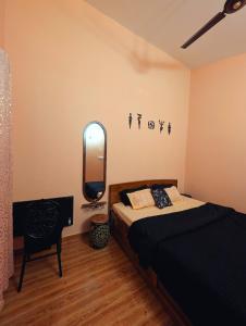 a bedroom with a bed and a mirror on the wall at Ketaki Homestay in Shānti Niketan