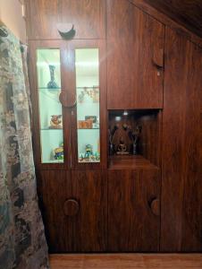 a wooden cabinet with glass doors in a room at Ketaki Homestay in Shānti Niketan +61 photos