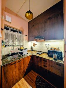a kitchen with wooden cabinets and a sink at Ketaki Homestay in Shānti Niketan