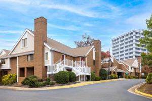 a large brick building with a building in the background at Tysons Corner Suites, A Baymont by Wyndham in Vienna
