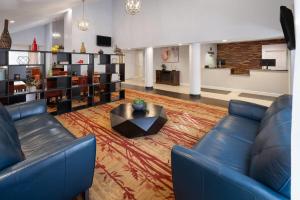 a living room with a blue couch and a table at Tysons Corner Suites, A Baymont by Wyndham in Vienna