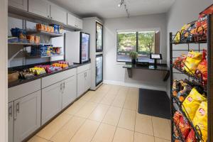 a kitchen with white cabinets and a food pantry at Tysons Corner Suites, A Baymont by Wyndham in Vienna