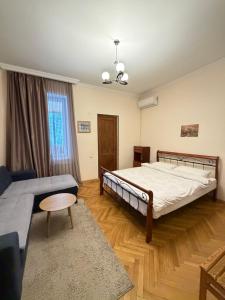 una camera da letto con un letto grande e un divano di Guest House Gardenia & Wine Cellar a Lagodekhi