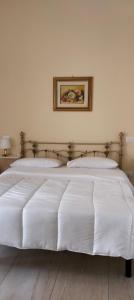 a large white bed with two pillows on it at Signora Irma in Margherita di Savoia