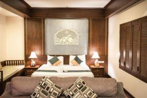 een slaapkamer met een bed en een bank bij Wiangkaew Hotel in Ban Fai Kaeo +187 foto's