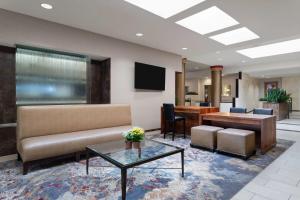 een lobby met een bank en een tafel en stoelen bij Wyndham Minneapolis South Burnsville in Burnsville
