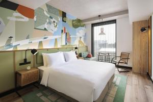 a bedroom with a large white bed and a desk at Caption By Hyatt Kabutocho Tokyo in Tokyo
