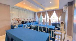 une grande chambre avec des tables et des chaises bleues dans l'établissement Hotel Estrella, à San Fernando