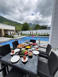 a table with food on it next to a pool at Palmen Villa Gabala in Gabala