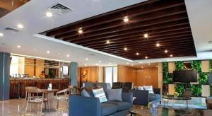 een woonkamer met een bank en een tv bij Hotel Dafam Pacific Caesar in Surabaya