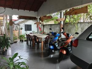 a motor scooter parked in front of a table at Samee Villa & Hostel Airport in Seeduwa