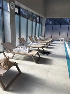 een rij ligstoelen in een kamer met een zwembad bij Ugam revers Apartments in Khumson