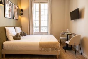 a bedroom with a bed and a table and a window at Stylish & Cozy Air-Conditioned Studio in Le Pré-Saint-Gervais