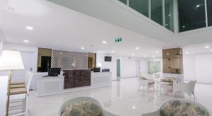 ein weißer Raum mit einer Lobby mit Stühlen und einem Tisch in der Unterkunft B2 Hua Hin Premier Hotel in Hua Hin