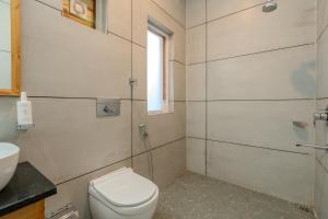 a bathroom with a toilet and a sink at SaffronStays Tirthan House - Balcony View in Bandal