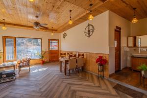 a kitchen and dining room with a wooden ceiling at SaffronStays Tirthan House - Balcony View in Bandal +26 photos