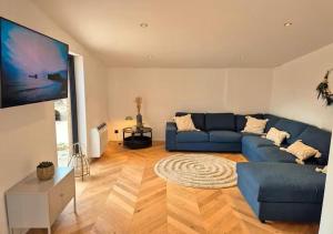 un soggiorno con un divano blu e una TV di Chez Simone Liège, bain nordique a Boncelles